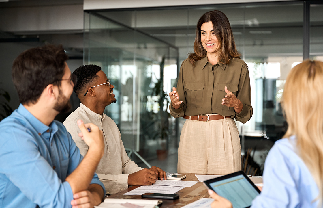 team meeting in an office with a women standing in front of seated people