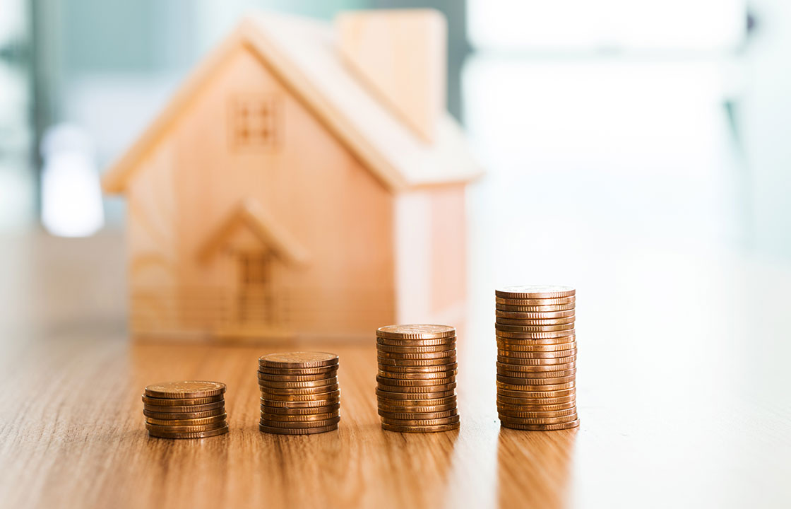 house with stacks of coins in front