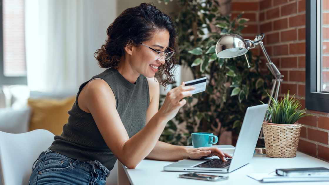 decorative image of a woman holding a credit card while at her laptop