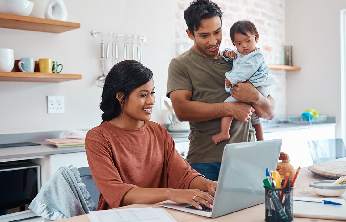 decorative image of a family in the kitchen standing behind a laptop