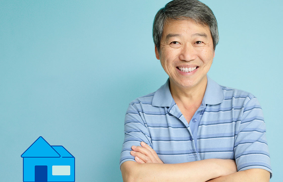 senior man with arms crossed standing beside a small house icon and a logo that says your money seniors