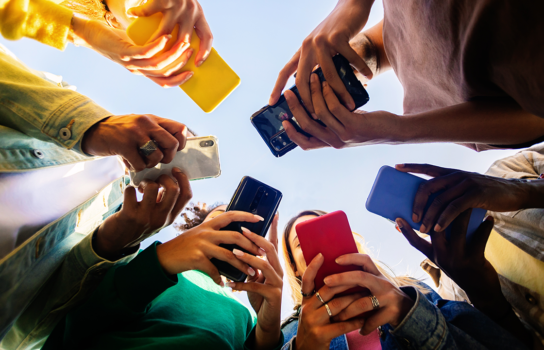 group of people in a circle holding their mobile phones