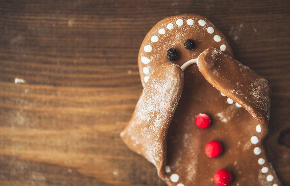 Biscuit en pain d'épice, sous forme de bonhomme avec les deux mains sur la bouche et un air surpris ou triste.